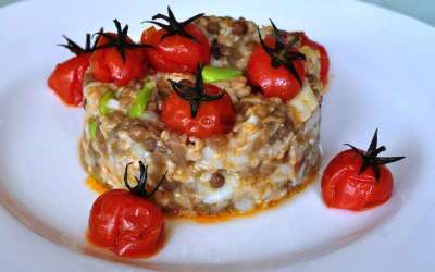 Cous cous integrale di farro con lenticchie, fave, baccalà e pomodori ciliegini arrostiti