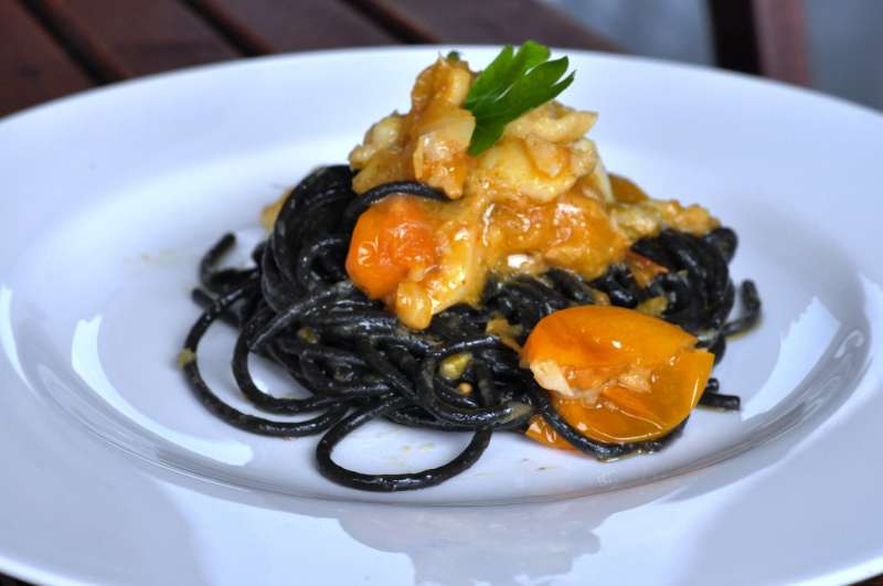Spaghetti al nero di seppia con baccalà e pomodorini gialli